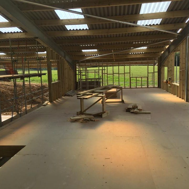 Large warehouse under construction with visible wooden beams