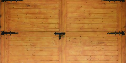 The texture of old wooden gates, old made of yellow treated wood with metal black door hinges