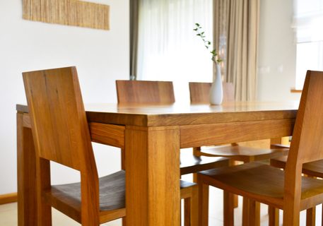 Natural oak wood dining table and chairs in neutral modern interior design house