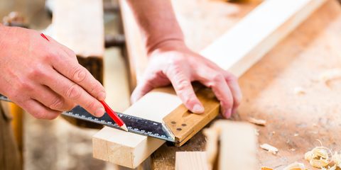 Carpenter working on wooden workpiece in his workshop or carpentry